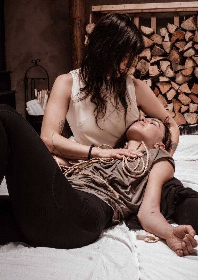 Teacher holding a woman in her arms with ropes over the chest after a sensual shibari session